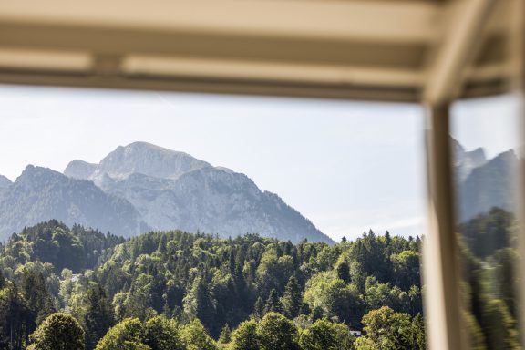 Der Blick aus dem Badezimmer auf den Jenner Berglandschaft mit bewaldeten Hängen und schneebedeckten Gipfeln im Hintergrund.