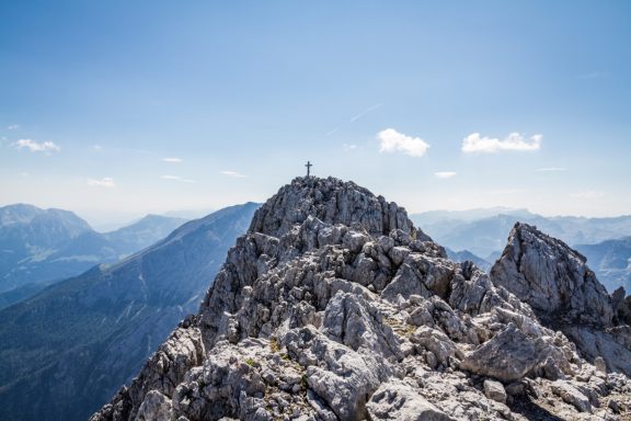 Ein Berggipfel, umgeben von einer beeindruckenden Berglandschaft.