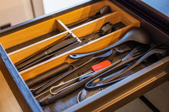 In der Küche finden Sie alle Utensilien, die Sie zum Kochen benötigen Küchenschublade mit verschiedenem Besteck und Kochutensilien.