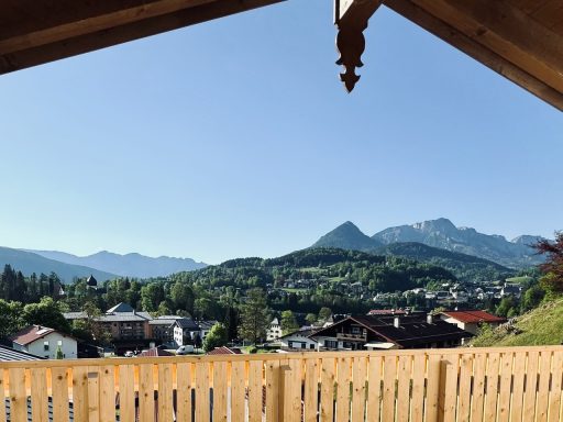 Blick auf eine Berglandschaft mit Häusern und blauem Himmel.