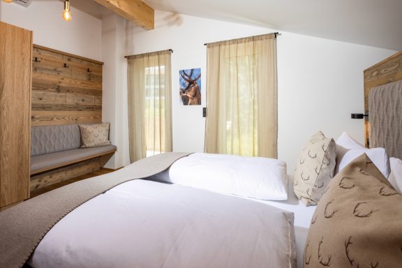 Die Schrank- und Ablageflächen bieten genügend Platz für all Ihr Gepäck Helles Zimmer mit zwei Betten, Holzdekor und großen Fenstern mit Vorhängen.